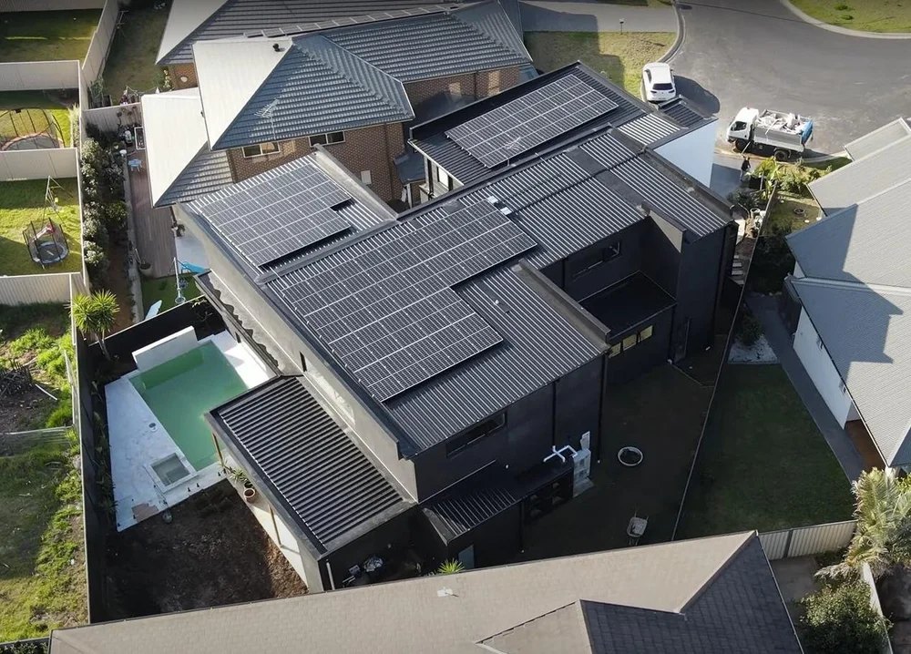 Aerial view of a dark roof covered in solar panels